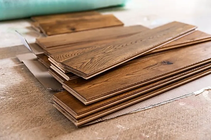 Hardwood, laminate and luxury vinyl plank flooring samples laid side by side for comparison