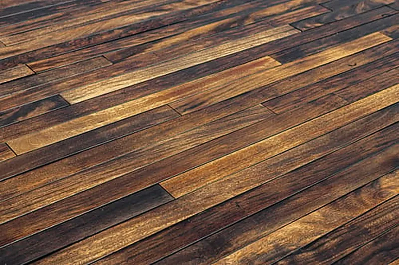 Rich dark hardwood planks showing wear patterns before refinishing