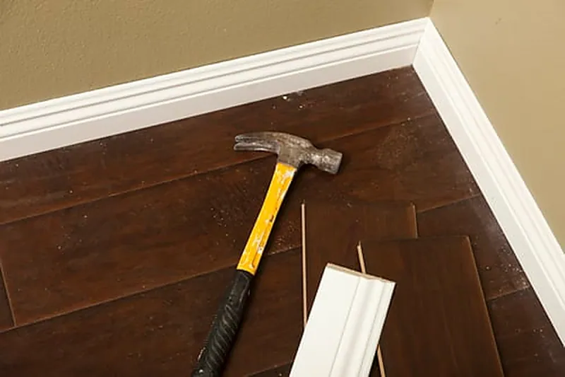 Hardwood board repair work at a baseboard during a MB Flooring & Home Services floor repair in Washington